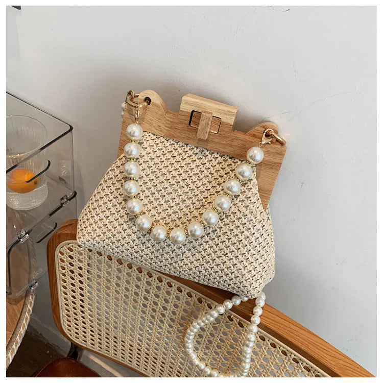 Women's straw woven shoulder bag with beach pearl chain detailing and horizontal square shape