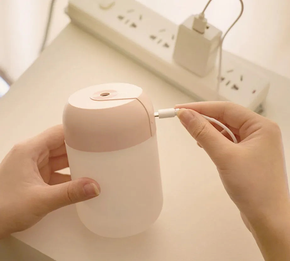 White cylindrical USB-powered mini humidifier on a desktop.