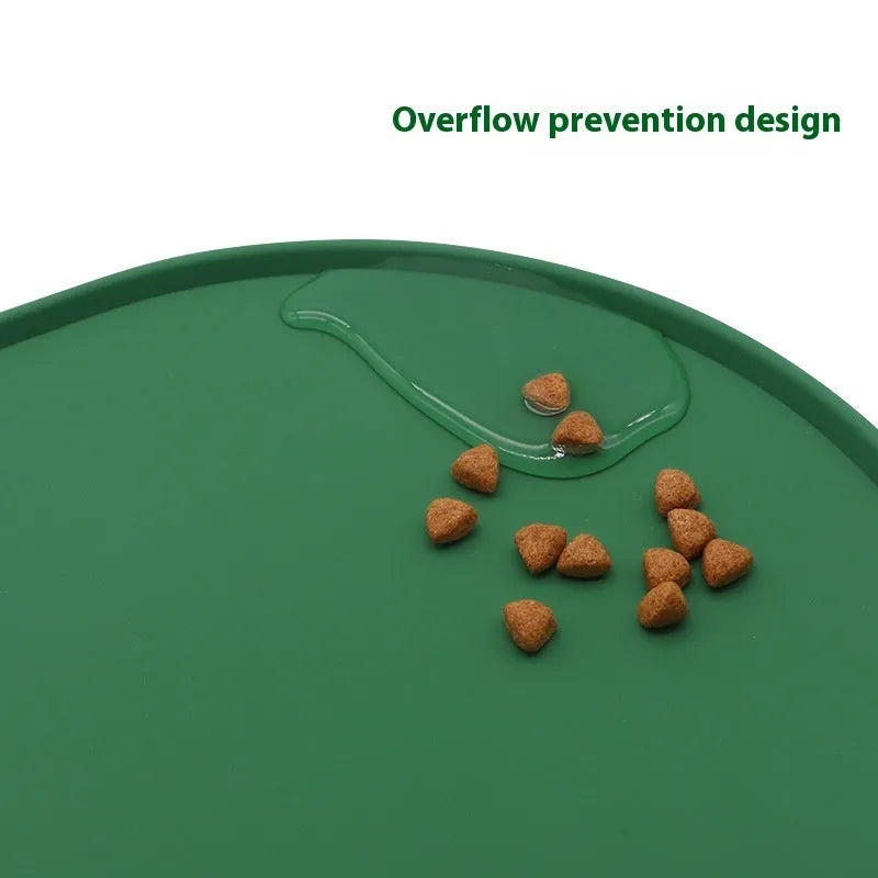 Green silicone waterproof placemat for cat bowls on a wooden floor.