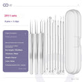 Four silver metal acne needles with fine pointed tips laid out on a surface.
