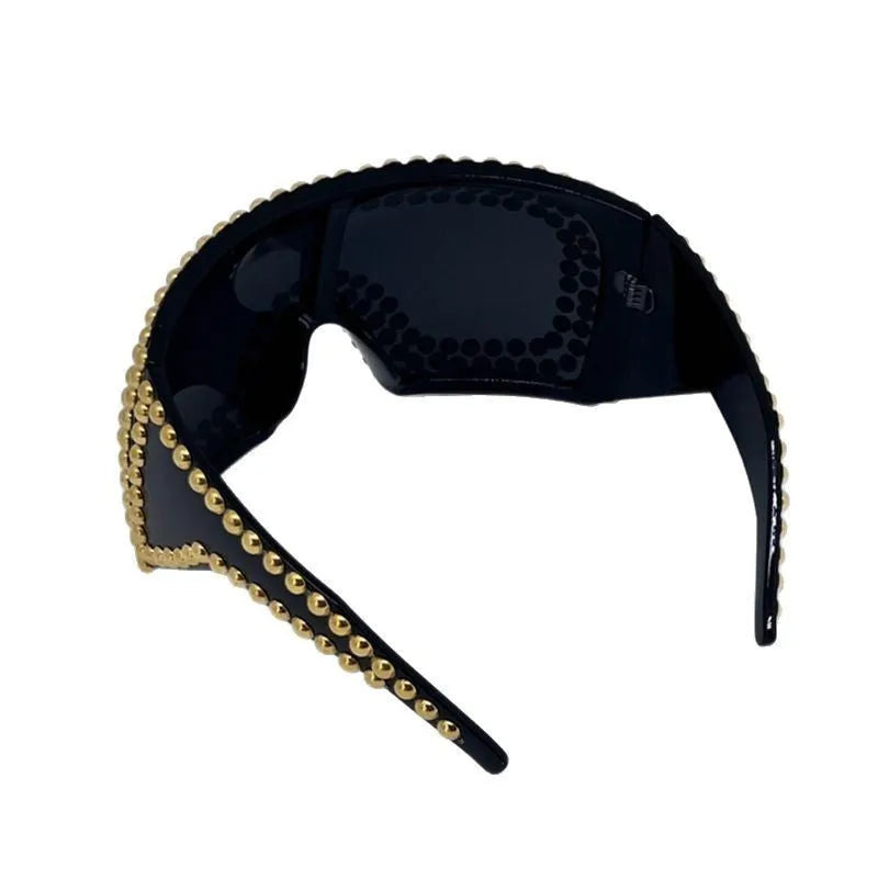 Punk sunglasses with large square frames and metal rivet details in gold colour
