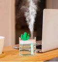 Transparent green cactus USB portable humidifier on desk showing water level inside plastic body
