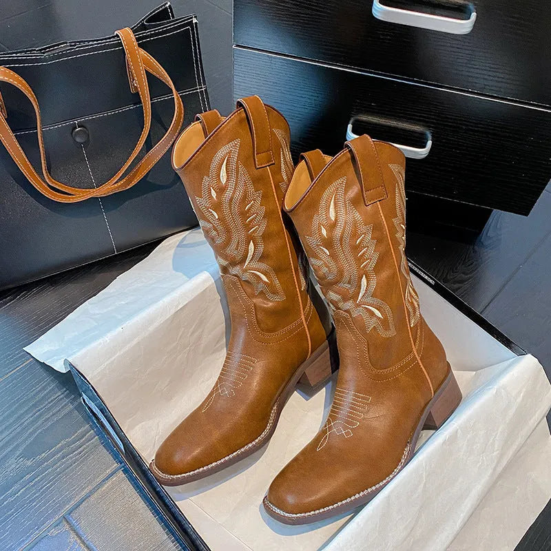 Brown women's mid-calf boots with embroidery detail on the shaft, shown from the side.