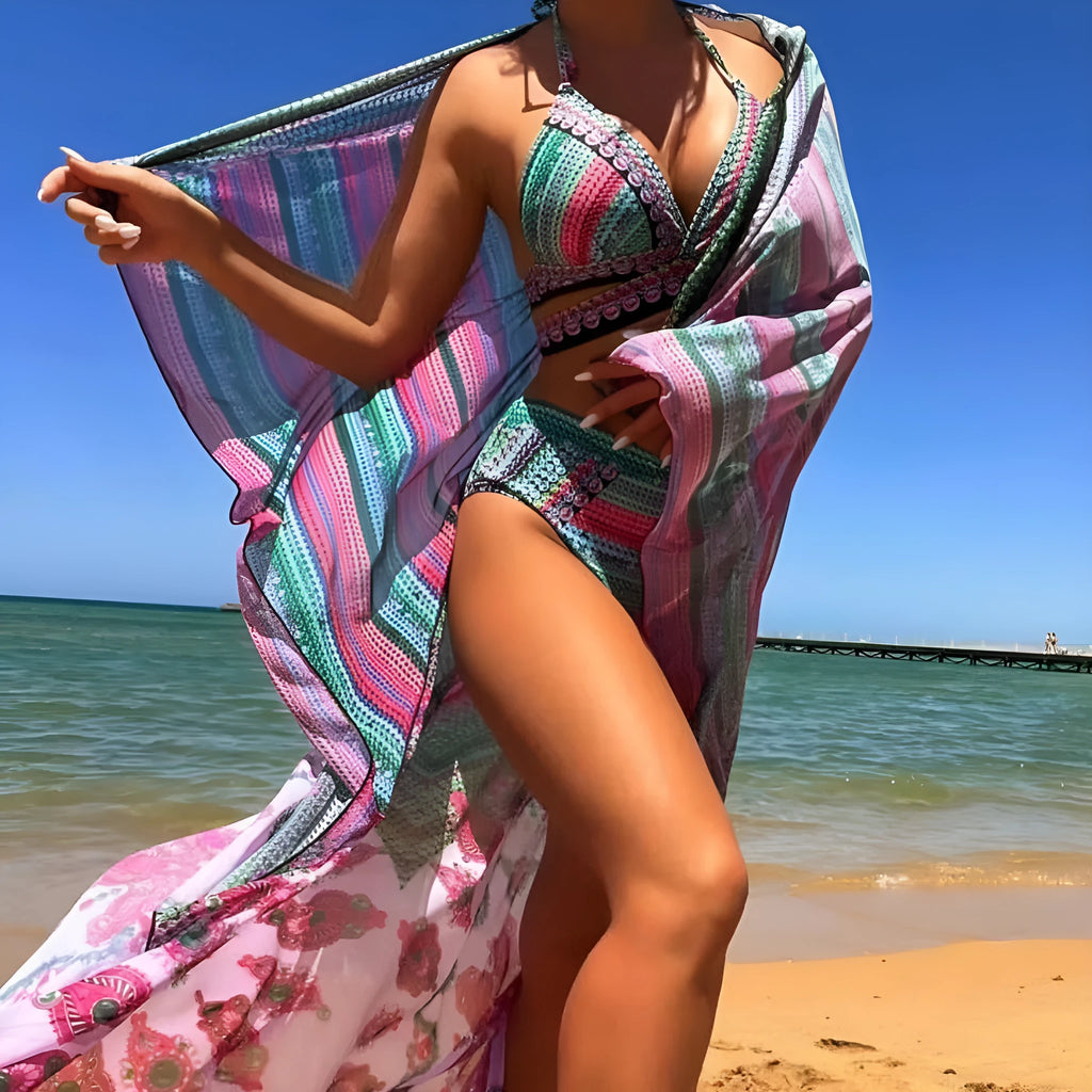Women's blue three-piece bikini swimsuit with cross bandage top and high-waist briefs with sheer veil side splits.