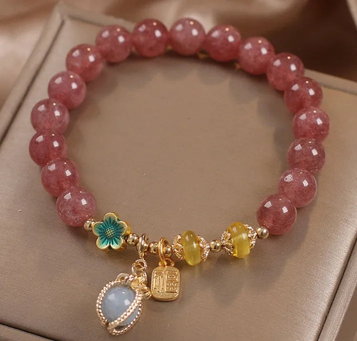 Natural strawberry quartz beaded bracelet red alloy with rhinestone details on white background