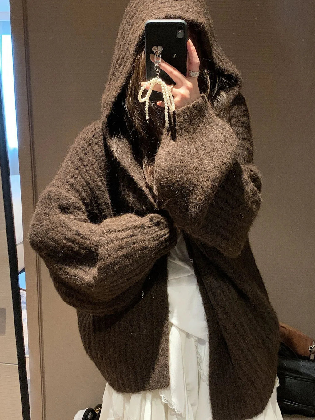 Women's dark grey loose-fit hooded cardigan sweater with chunky acrylic knit texture.
