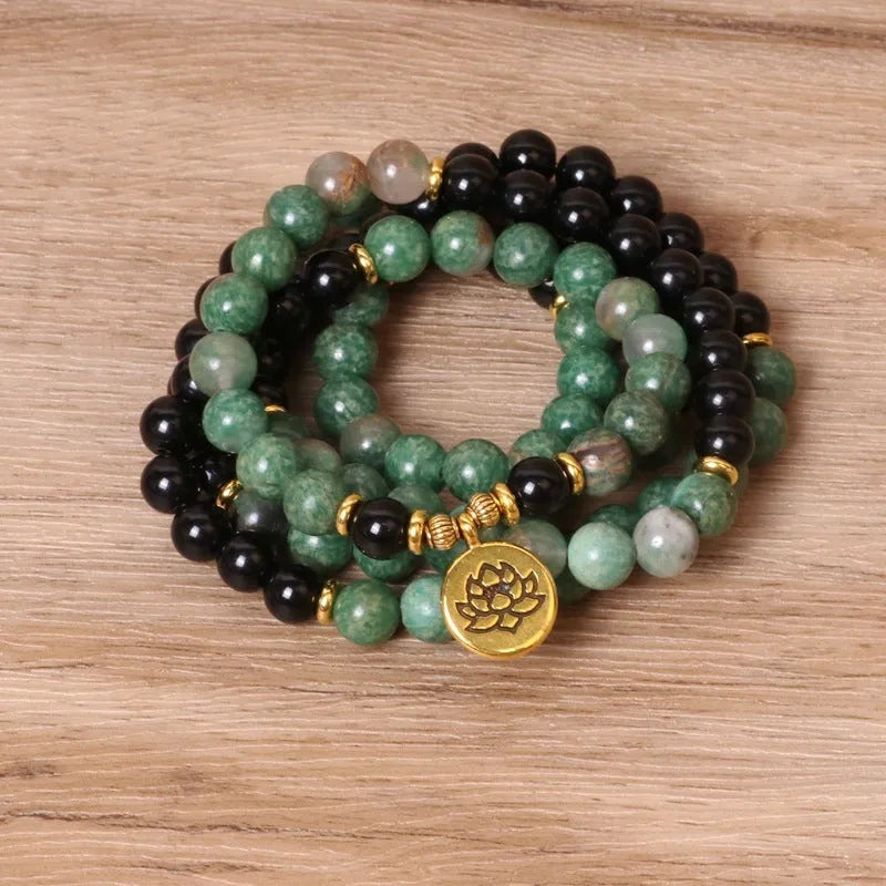 Green and black alloy bead elastic long bracelet on wrist.