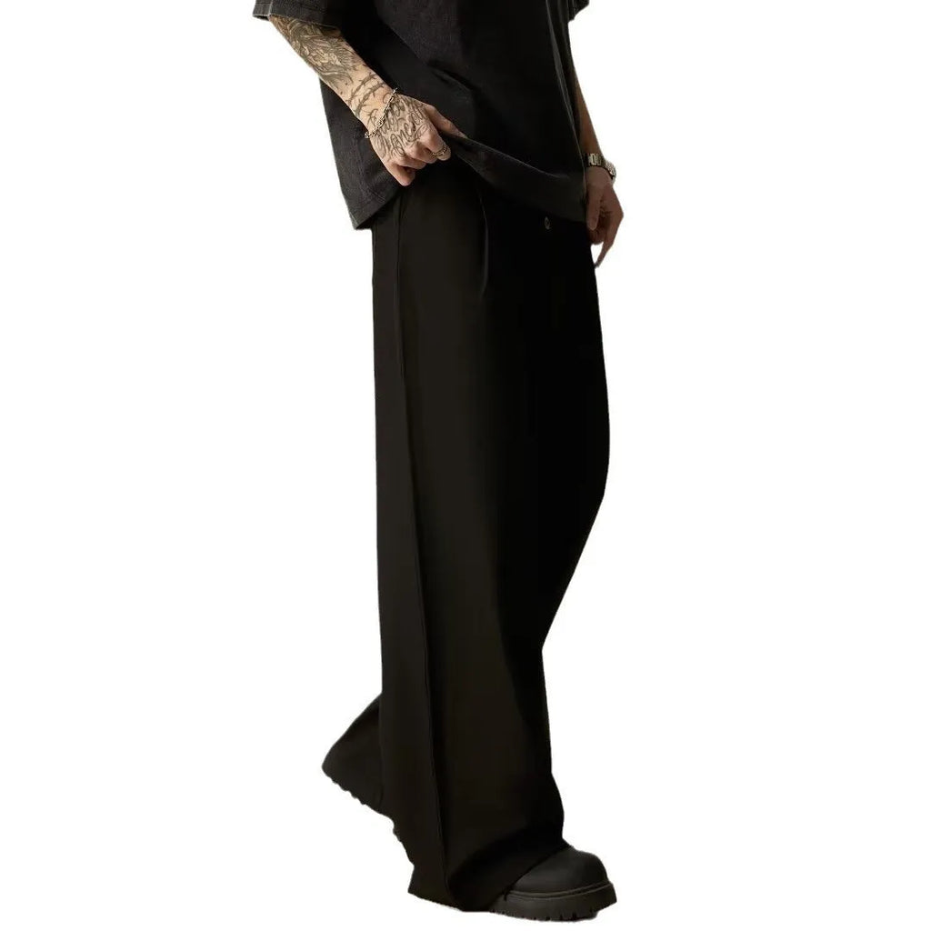 Men's solid black casual straight-leg trousers with a wide-leg fit and button fly on a neutral background.
