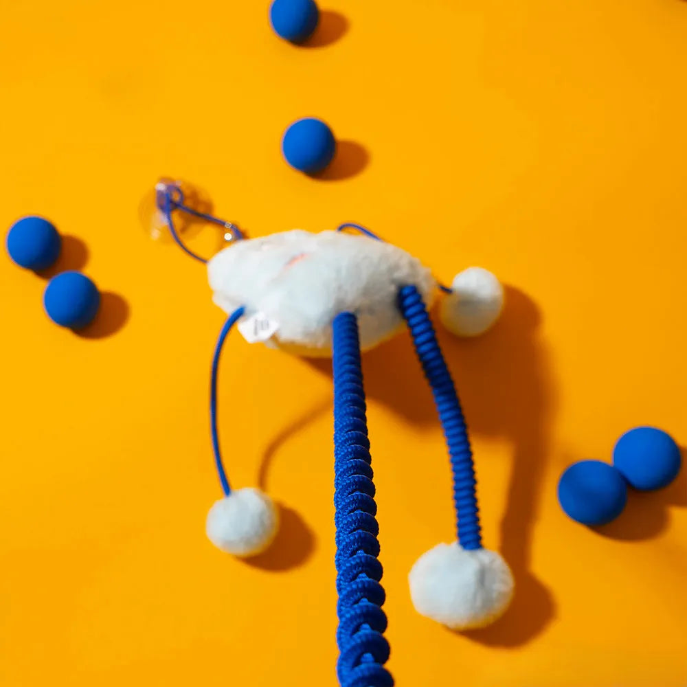 Blue plush cat toy with mint bell and elastic rope on floor