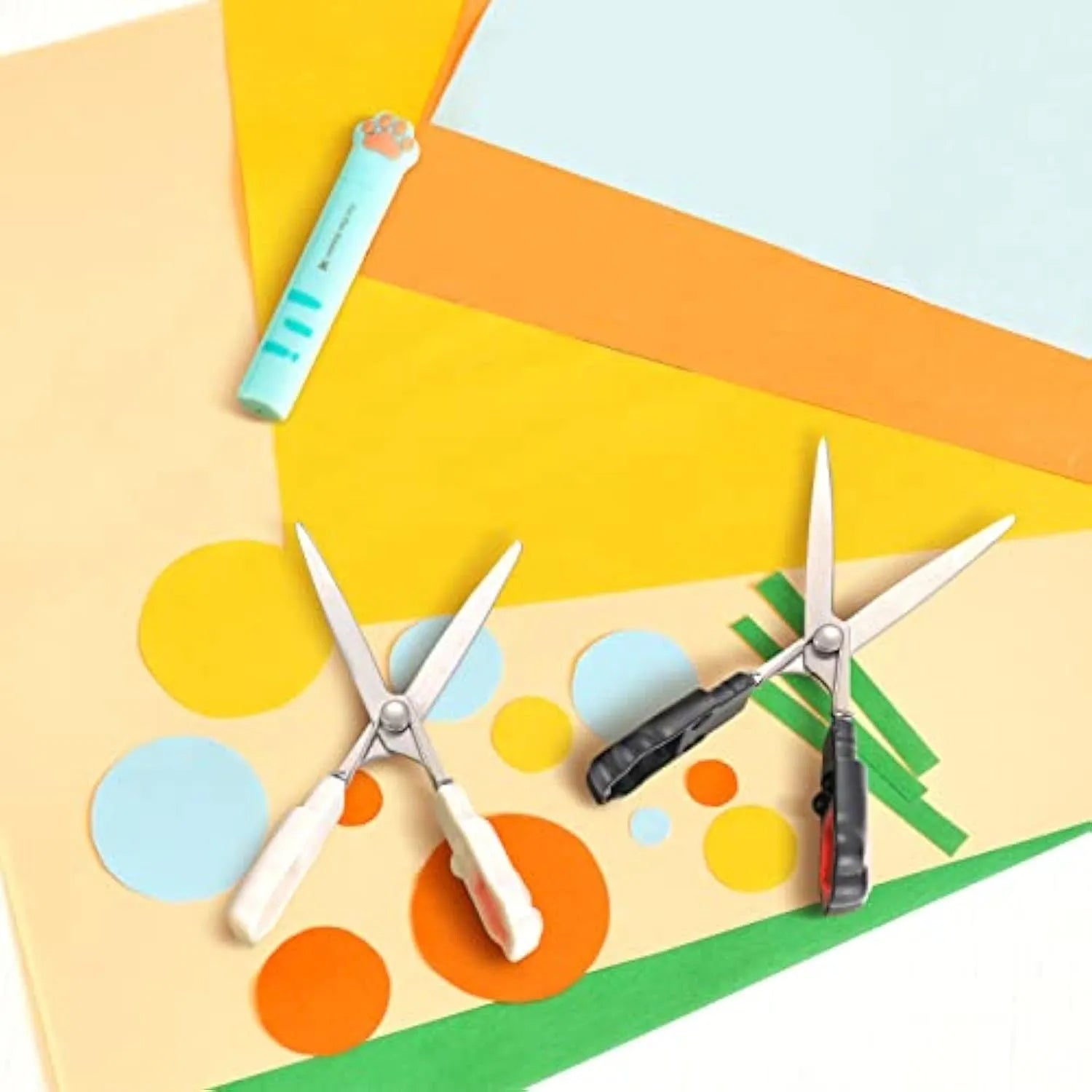 Small folding scissors with cat paw design on handles in choice of four colours, shown with blades safely closed.