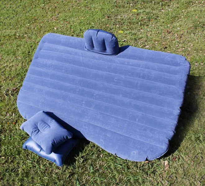 Black inflatable car bed with pillows, set up in the back of a five-seater car.