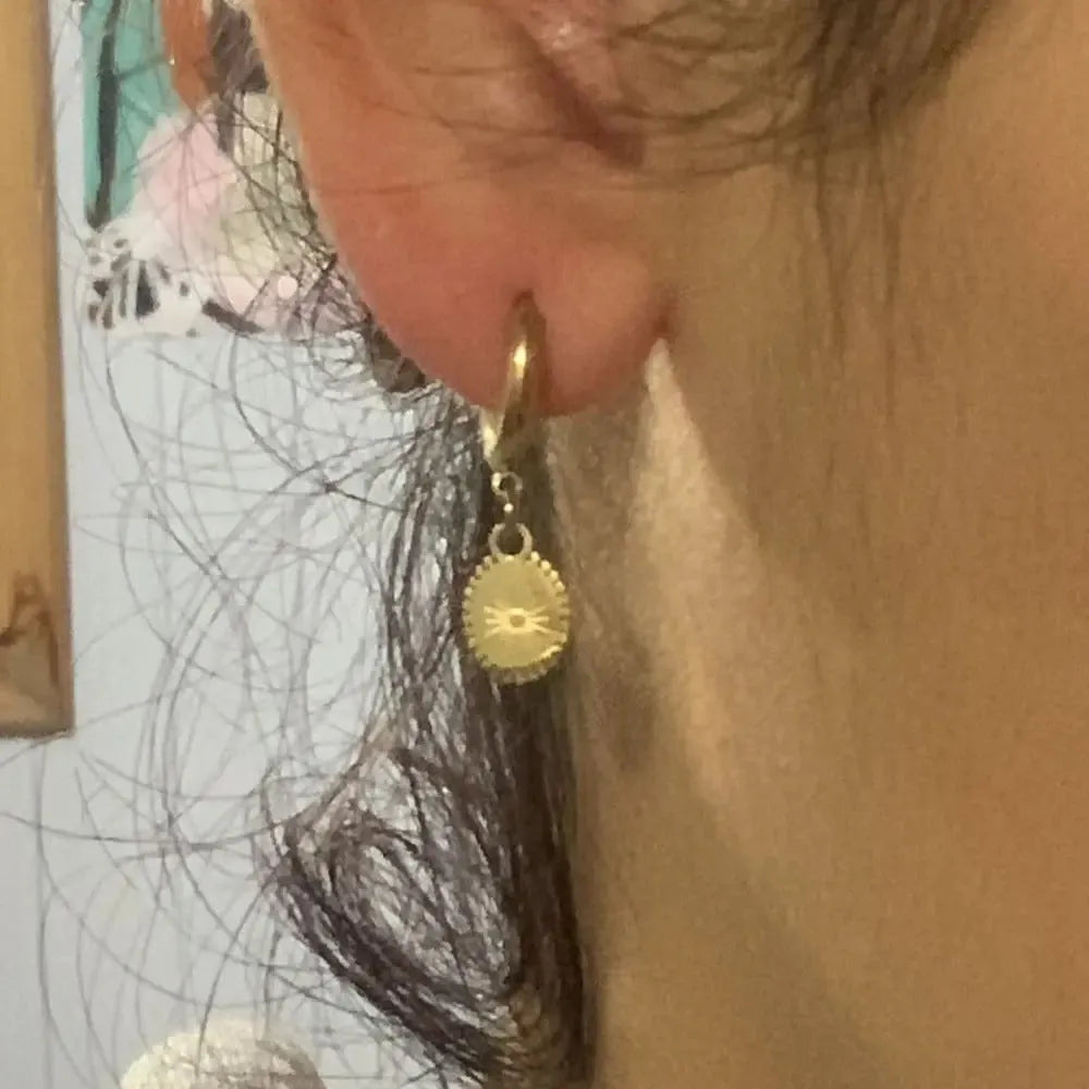 A pair of stainless steel geometric ear button earrings with an ellipse detail, style XY-EH005.