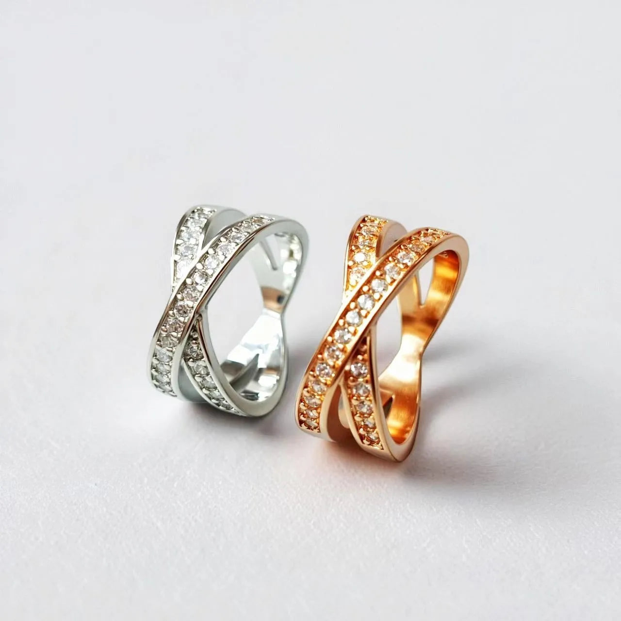 Copper metal cross ring with micro-inlaid zircon stones in silver electroplated finish showing geometric heart-shaped design