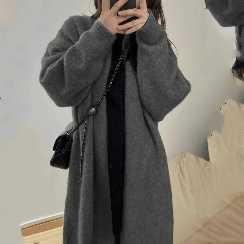 Loose large knitted women's cardigan sweater in chenille fabric showing 3D stitch pattern.