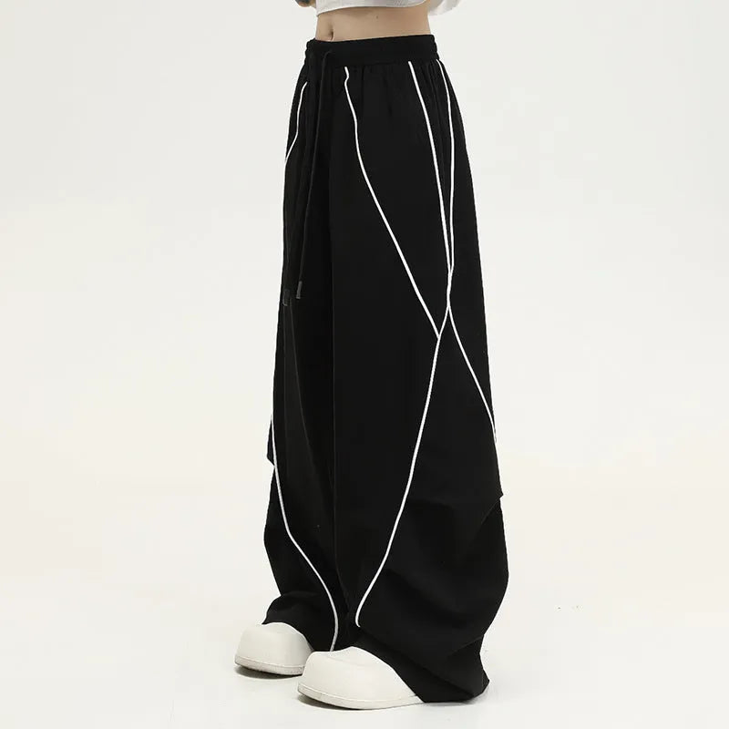 Black pleated wide-leg trousers with striped pattern showing mid-waist design and loose fit