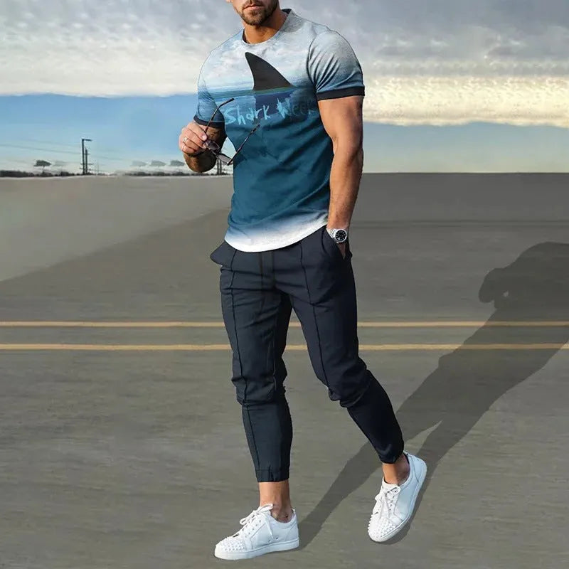 Man wearing a light grey short-sleeved pullover and matching trousers from a men's two-piece tracksuit set.