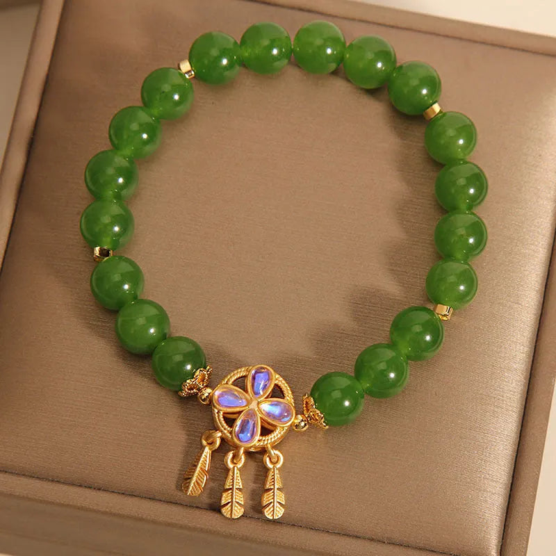 Women's green jasper crystal bracelet with four-leaf clover and dream catcher pendant, original design, on white background