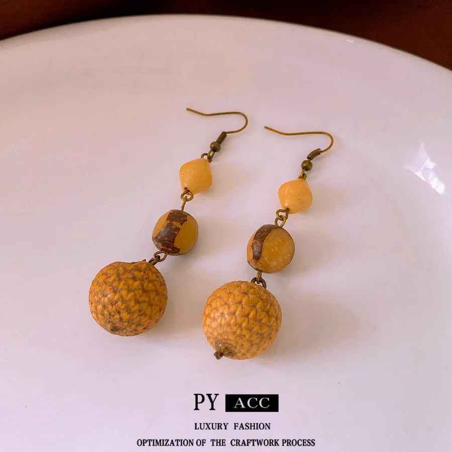 Retro ethnic style brown resin fruit core tassel earrings with geometric round design for women.