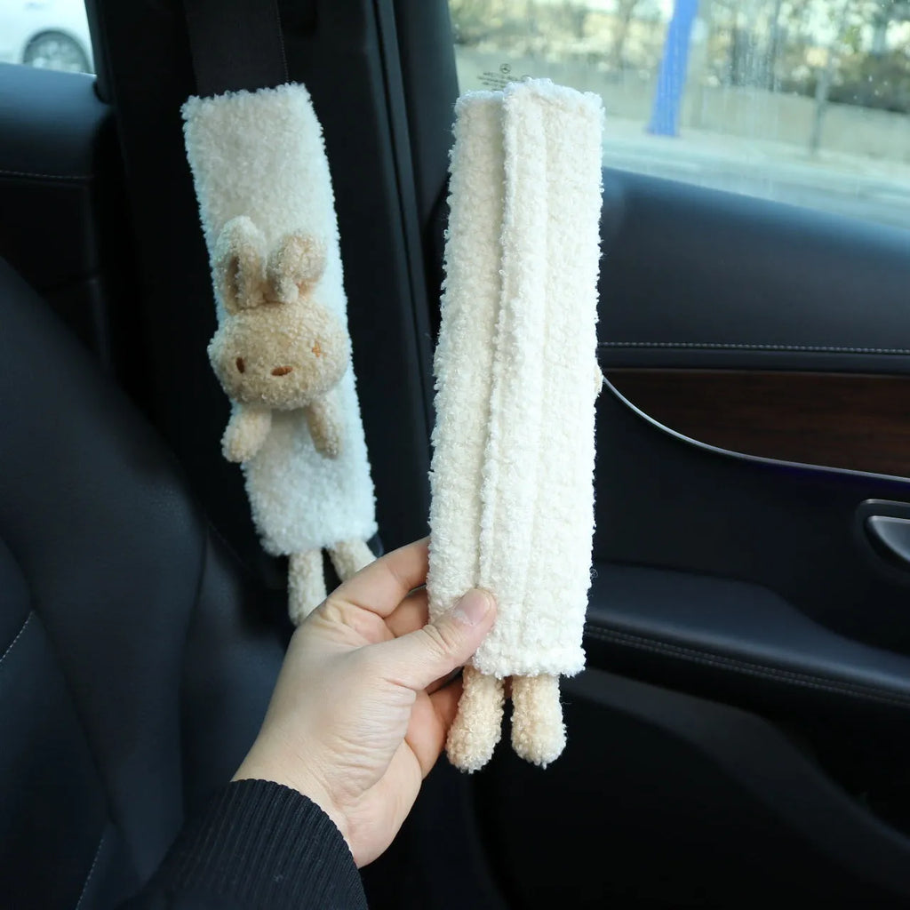 Soft plush car seatbelt shoulder protector with cartoon bear and rabbit designs made from lamb wool.
