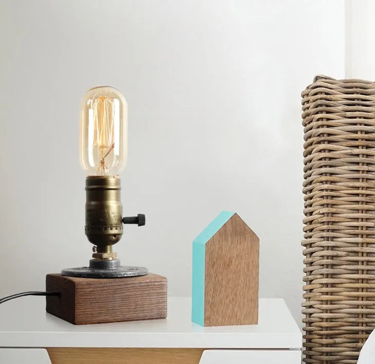 Small wood and iron water pipe style table lamp on a table