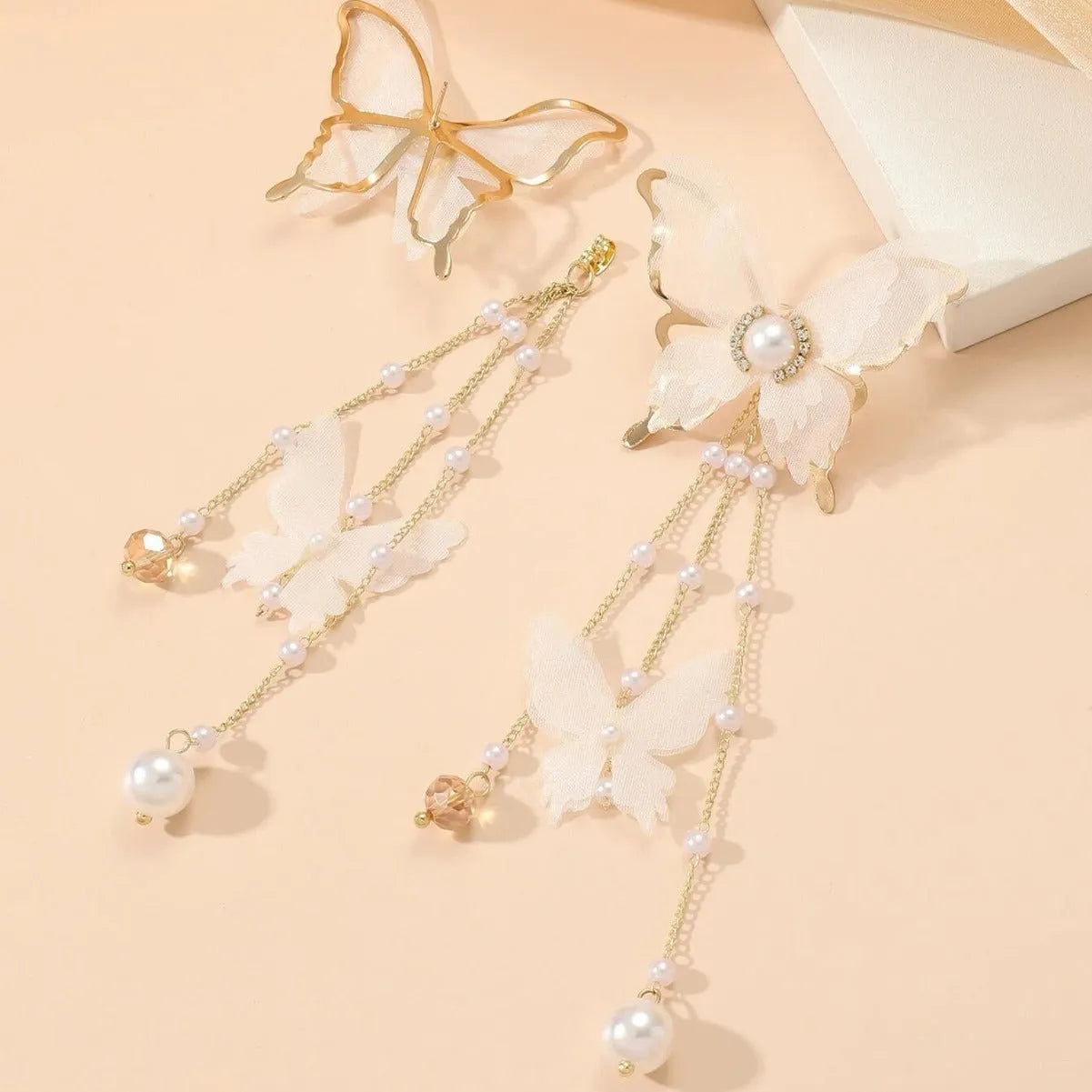White butterfly-shaped earrings with tassel design featuring lace patterns, pearls, and rhinestones