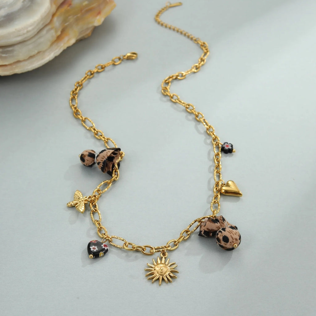 Stainless steel necklace with geometric pendant showing leopard spots, love hearts and flowers in gold finish