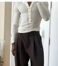 Men's cream-coloured ribbed long-sleeve Henley top with button placket on a mannequin.
