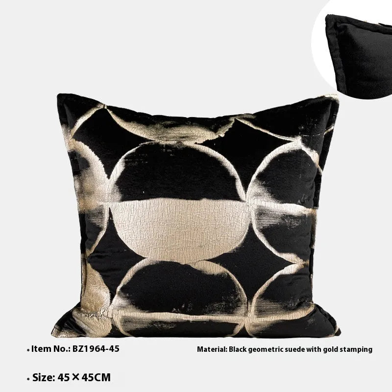 Black gold abstract patterned flannel decorative cushion on a sofa.