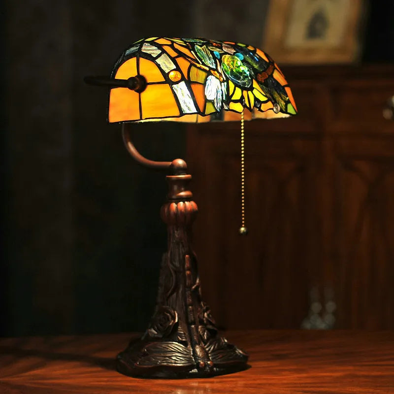 10-inch Tiffany desk lamp with coloured stained glass shade and resin base on a wooden table.