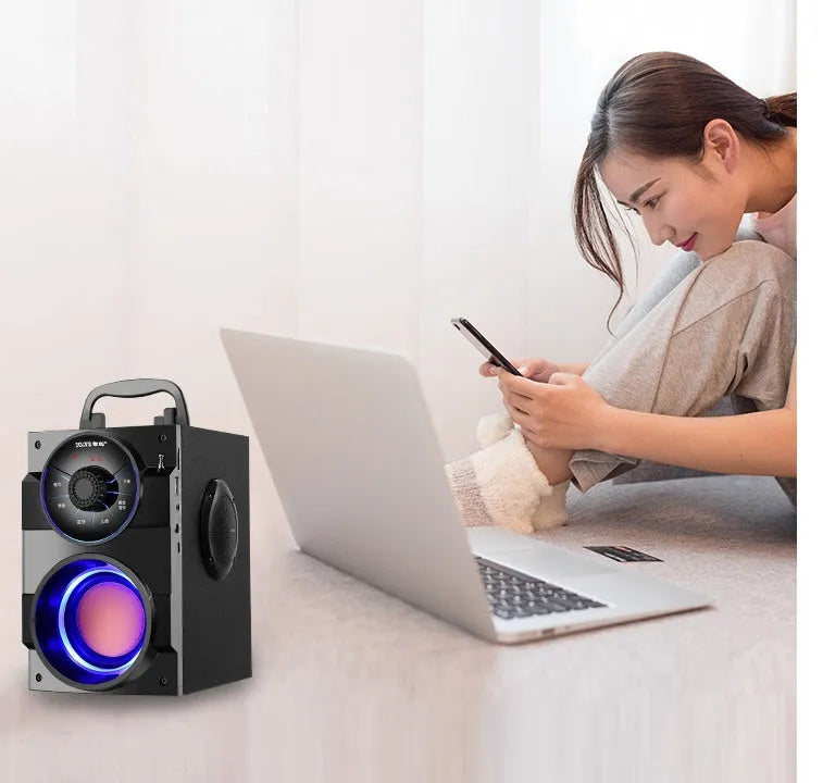 Black portable mini home audio system with subwoofer, 3.5mm audio cable, and USB charging cable.