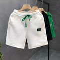 Men's solid colour polyester casual sports shorts with elastic waistband in white, black, or green.