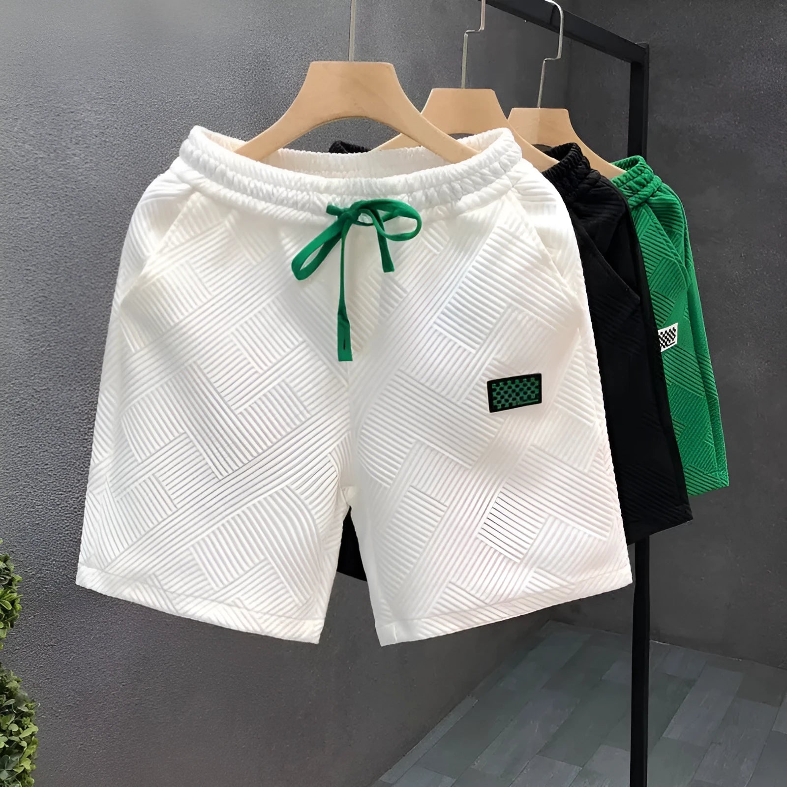 Men's solid colour polyester casual sports shorts with elastic waistband in white, black, or green.