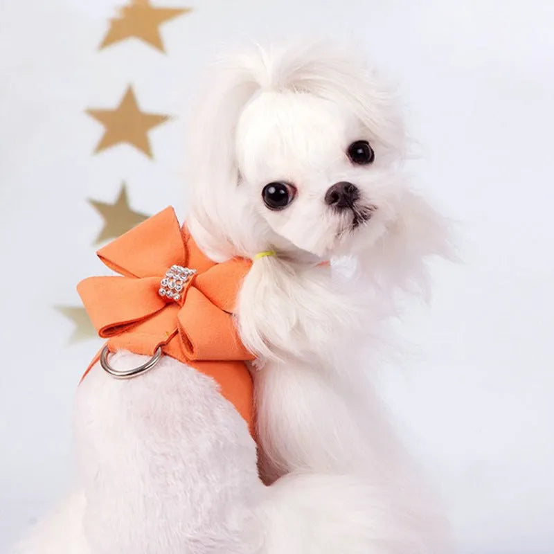 Pink microfiber dog chest strap with a large white bowknot, showing adjustment buckle and D-ring.