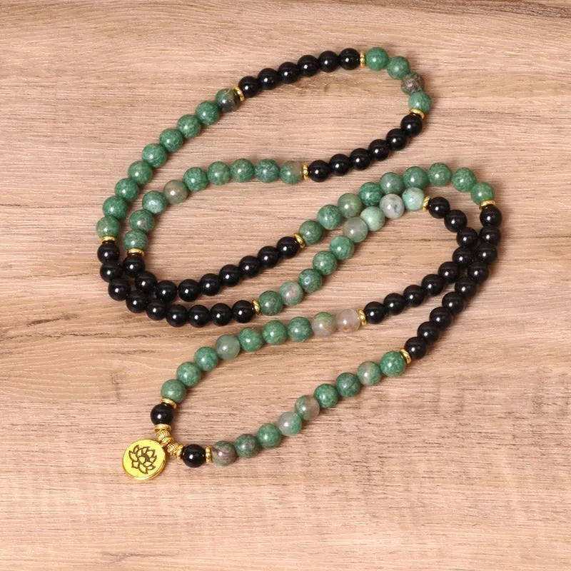 Green and black alloy bead elastic long bracelet on wrist.