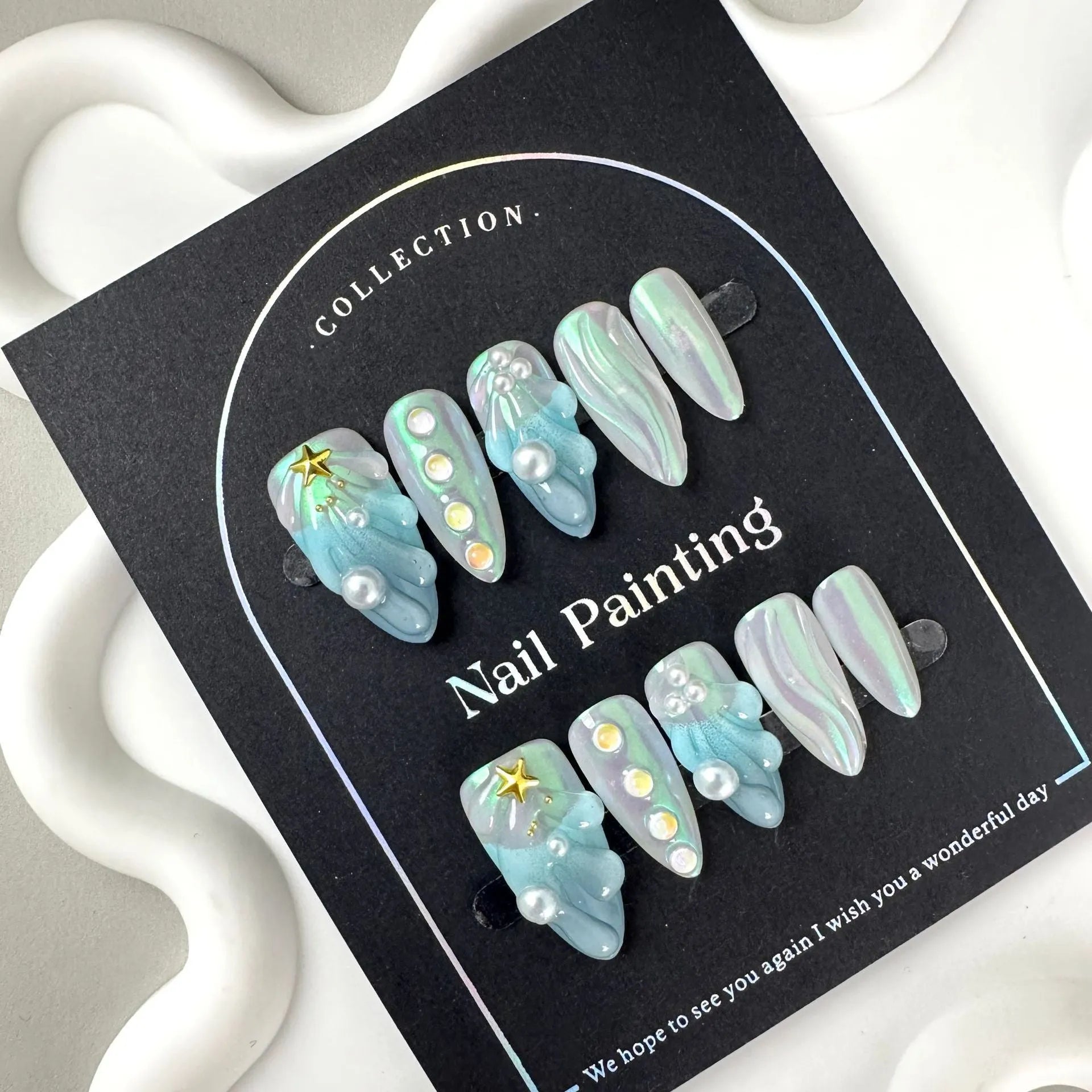 Blue plastic HAILANG false nail tips set showing sizes XS, S, M, L on a card.