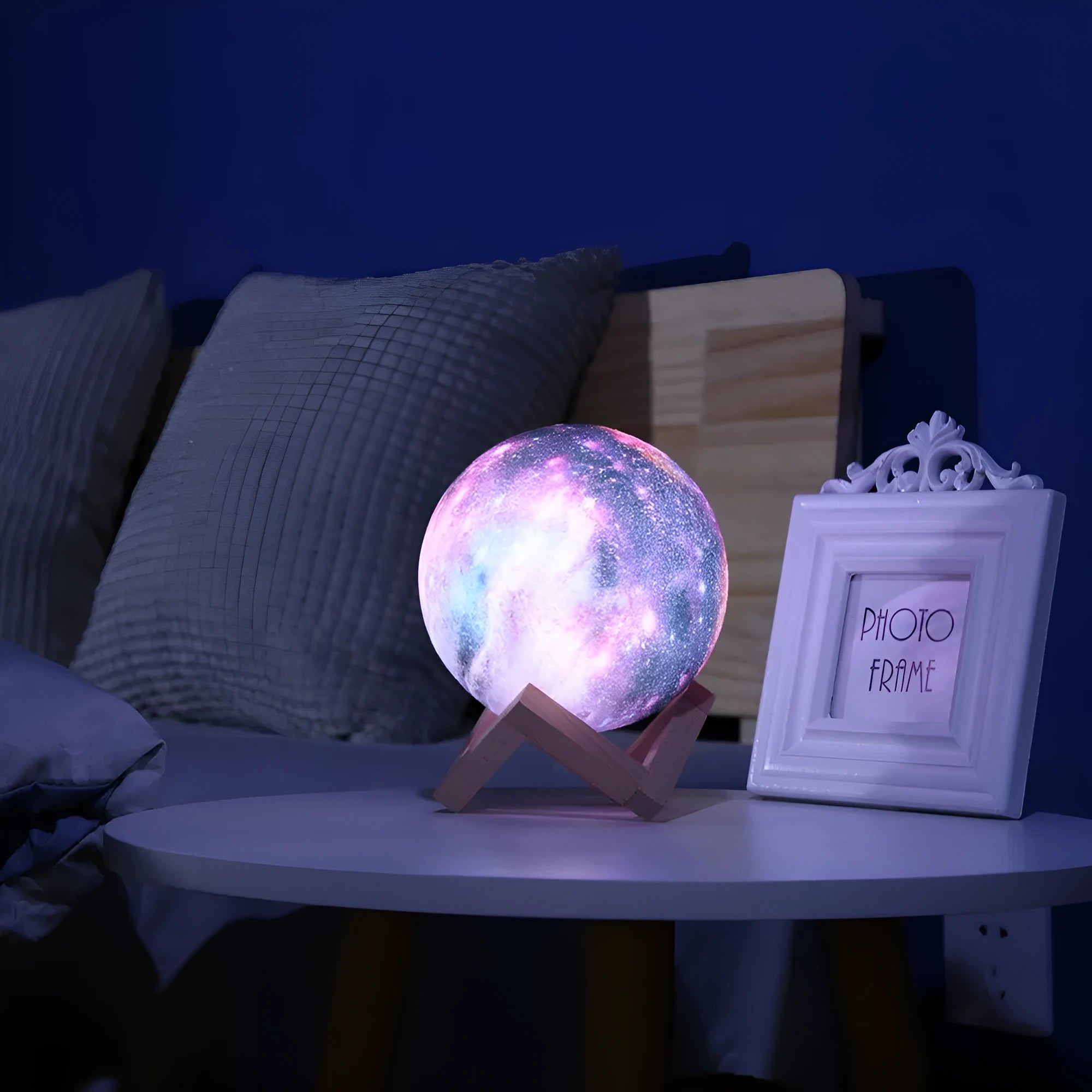 3D printed spherical lunar night light with multi-colour LED glow on a dark surface.