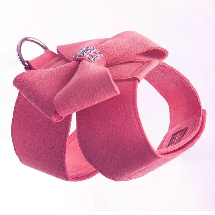Pink microfiber dog chest strap with a large white bowknot, showing adjustment buckle and D-ring.