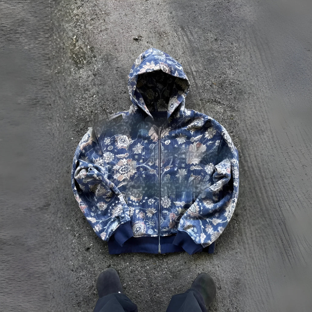 Man wearing a blue loose-fit zip-up hoodie with a hood, shown in a casual setting.