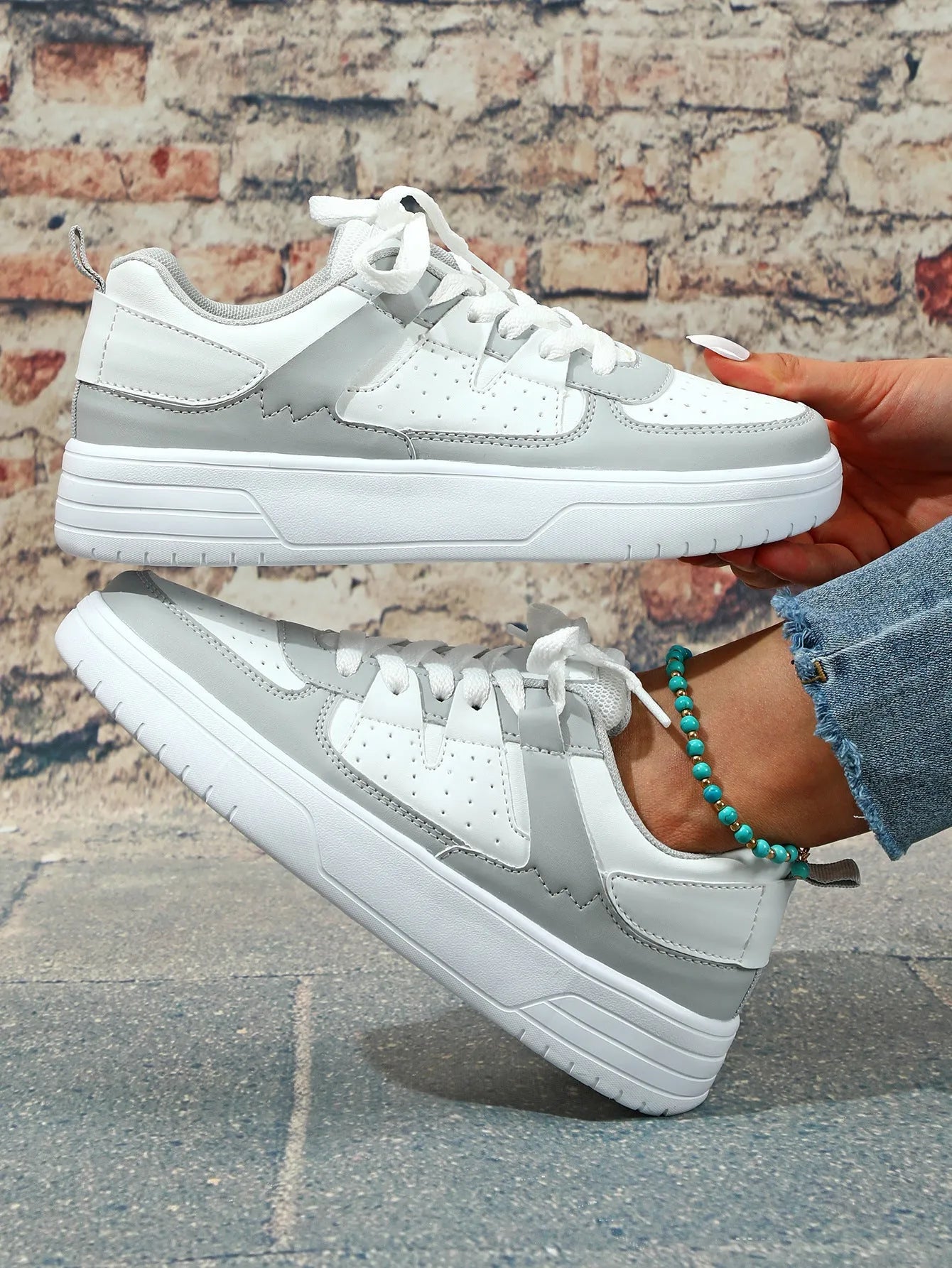 Casual solid colour low top sports shoes with front lace-up, round toe, and metal accents on a white background