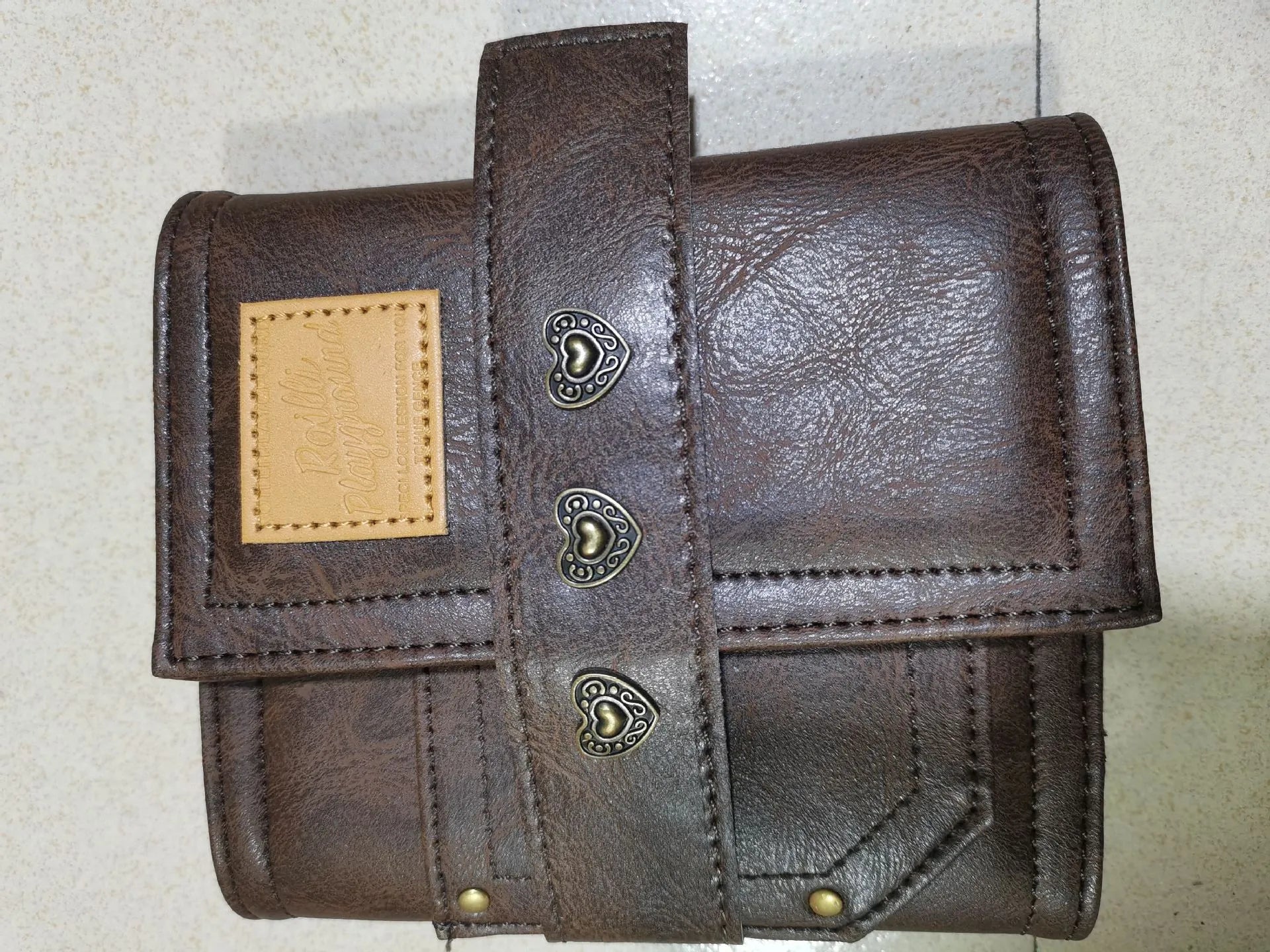 Brown A7 notebook with leather-style buckle closure showing loose-leaf binding
