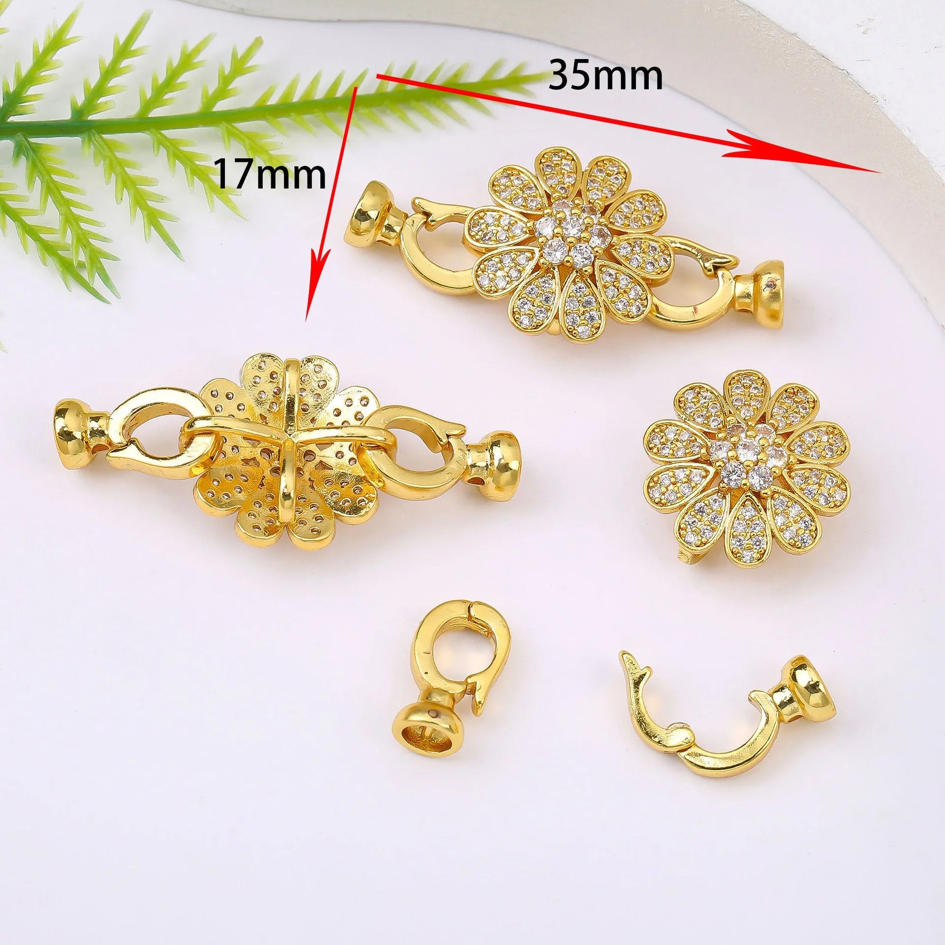 Small gold-coloured metal jewellery clasp on a white background.