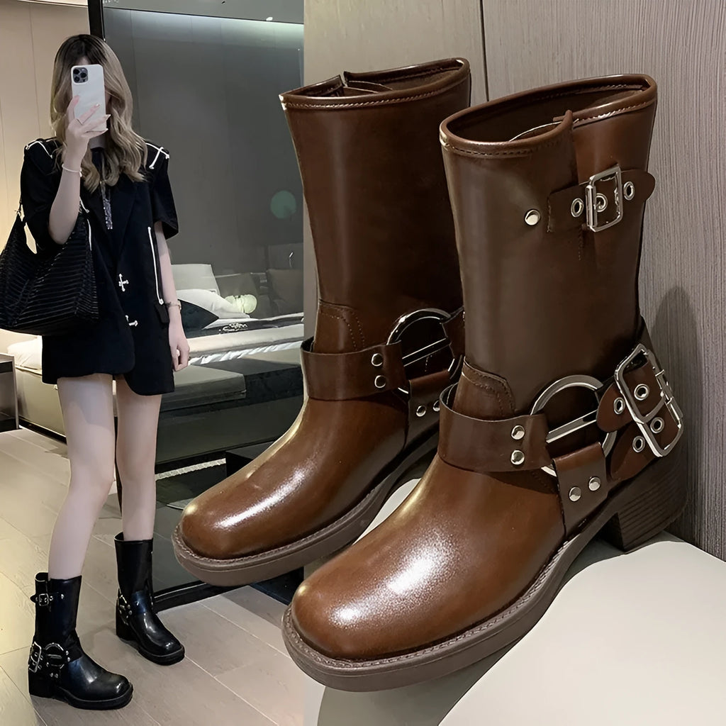 Black platform calf-length women's boots with a large decorative buckle on the shaft.