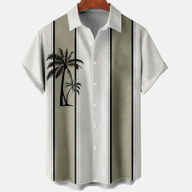 Man wearing a slim fit short sleeve shirt with a colourful 3D floral print, on a beach.