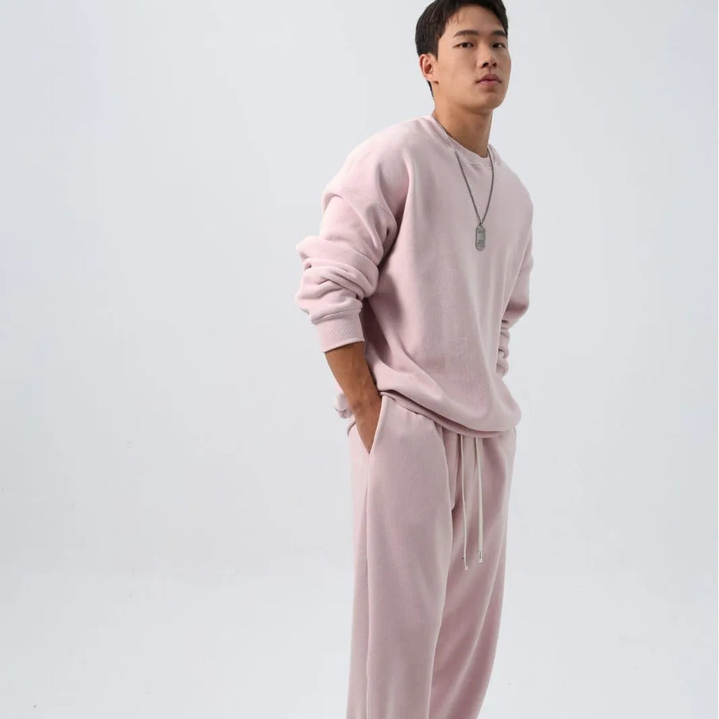 Man wearing a black loose-fit polar fleece sports suit with crew neck top and padded trousers for winter.
