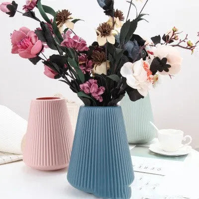 Melamine plastic decorative vase in blue colour on desktop with floral arrangement