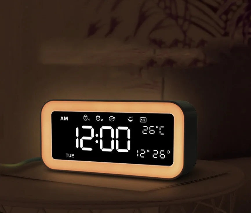 Blue rectangular LED digital alarm clock with atmosphere light on a bedside table.
