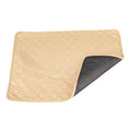 Two washable dog pee pads in grey and khaki on a floor, one with a small dog standing on it