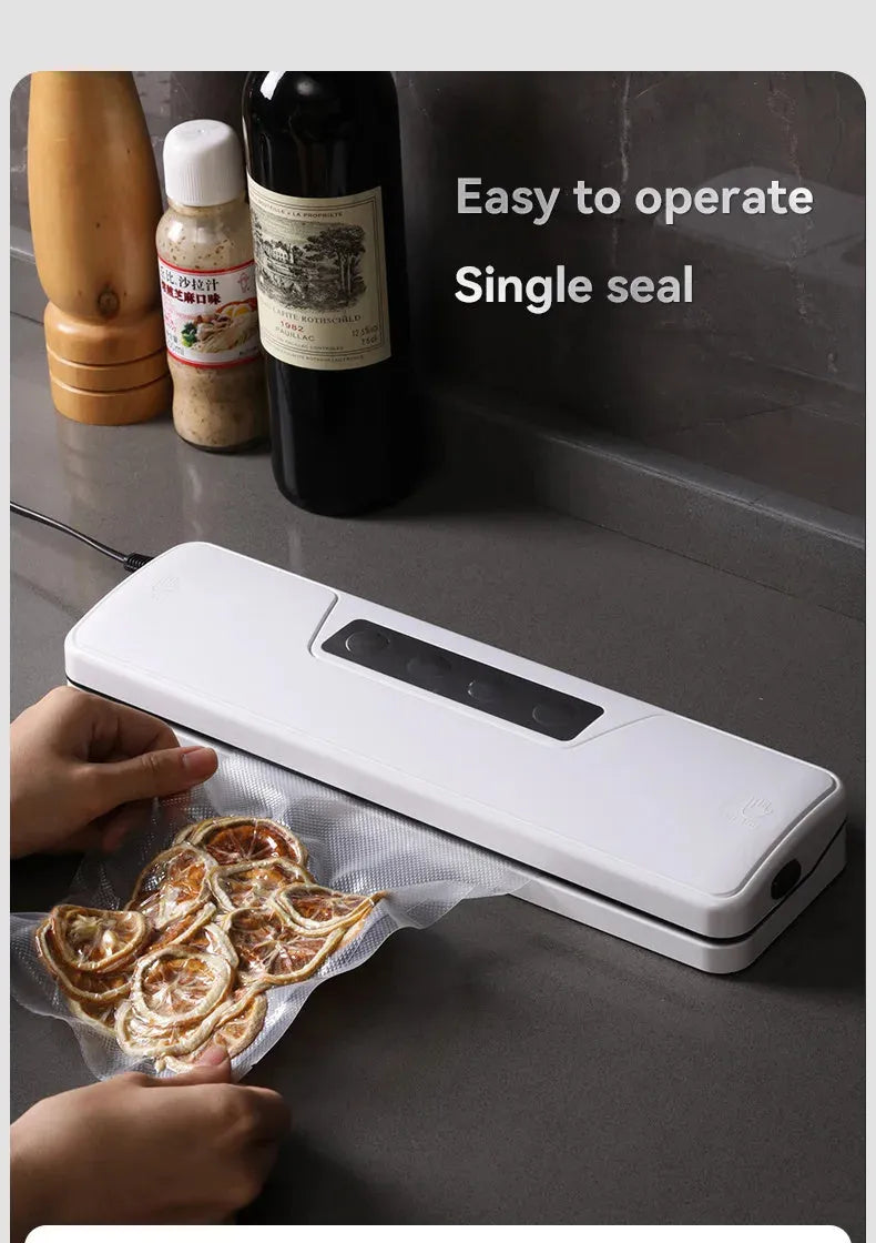 White automatic vacuum sealer machine for household food preservation on a kitchen counter.