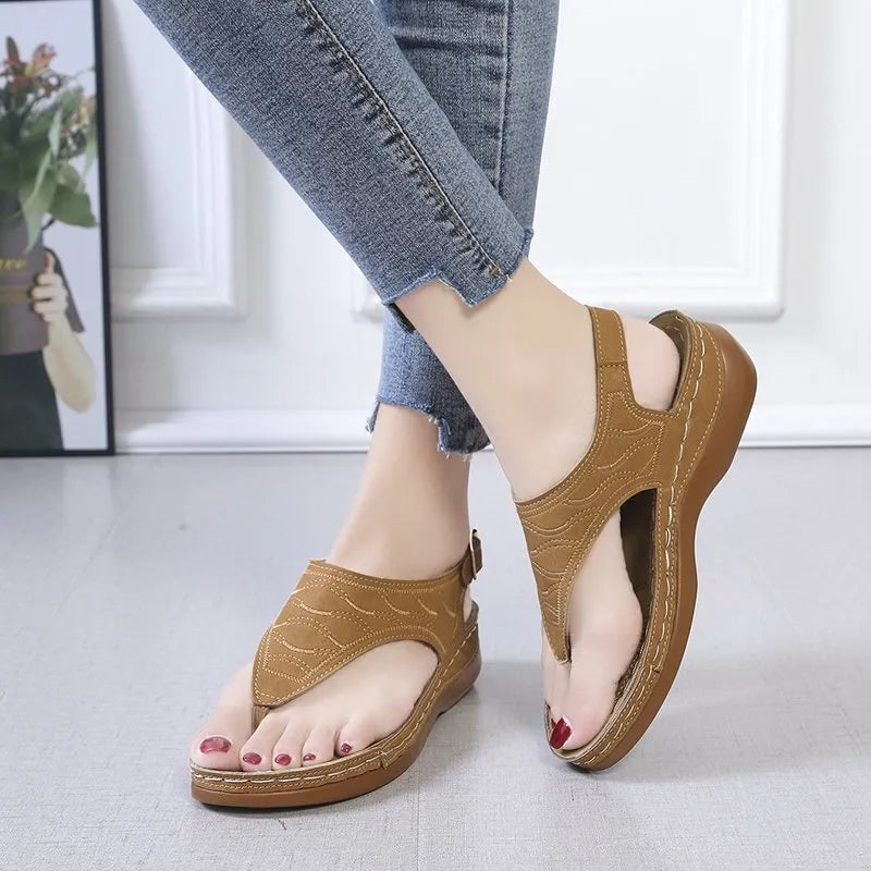 Women's black wedge heel sandals with an adjustable buckle strap on a light background.