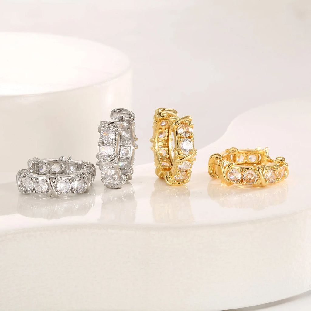 Geometric hexagonal clover cross shape earrings with ellipse detail, shown in gold and silver electroplated colours.